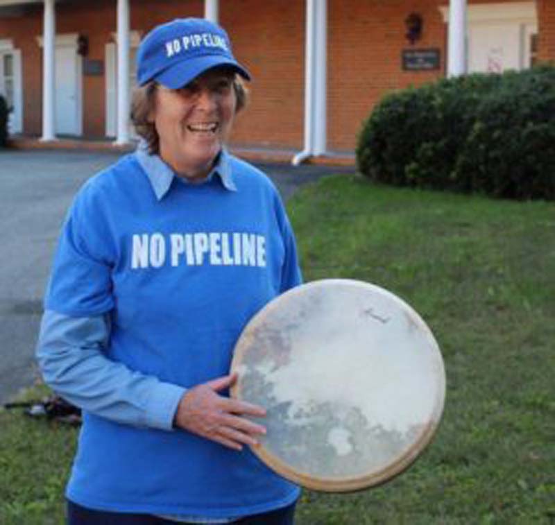 Pipeline protester Priscilla Sonne holds a drum as she and a small group of others sing before Monday's meeting. COURTESY OF MARION KANOUR