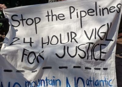 Ruby Laurie holding a banner Stop the Pipelines